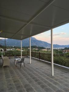 a patio with chairs and tables on a roof with mountains at My Olive Tree House in Kalamata