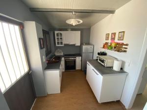 a small kitchen with white appliances and a window at My Olive Tree House in Kalamata