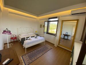 a bedroom with a bed and a table and a mirror at My Olive Tree House in Kalamata