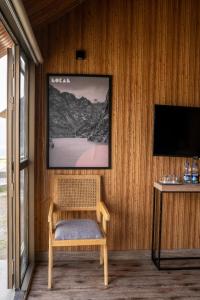 a room with a chair and a television on a wall at LOKAL Rooms x Hunza (5 Peaks) in Baltit
