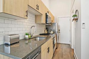 una cucina con armadi in legno e lavandino di Stylish Apt with a Modern Kitchen - Wilson 418 a Chicago