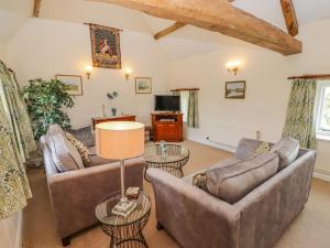 a living room with two couches and a tv at Pheasant Cottage in Burford