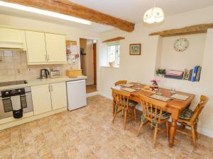 a kitchen and dining room with a table and chairs at Pheasant Cottage in Burford