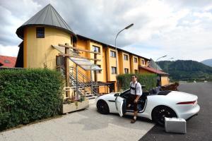 uma mulher sentada num carro branco em frente a um edifício em Lorenzer Schlafstubn em Sankt Lorenzen im Mürztal