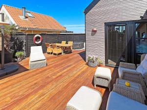 een patio met een houten terras met stoelen en een tafel bij Holiday home Otterup XXX in Otterup