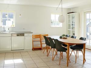a kitchen with a wooden table and chairs at Four-Bedroom Holiday home in Gjern 1 in Gjern