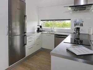 una cucina con frigorifero in acciaio inossidabile e armadietti bianchi di Holiday Home Haslevgårde a Haslevgårde