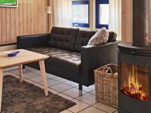 a living room with a couch and a fireplace at 8 person holiday home in L s in Læsø