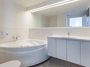 een witte badkamer met een bad en een wastafel bij 8 person holiday home in Bagenkop in Bagenkop