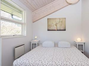 a white bedroom with a bed and two windows at Three-Bedroom Holiday home in Knebel 19 in Knebel