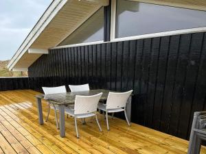 un patio con mesa y sillas en una terraza en 12 person holiday home in Hj rring, en Lønstrup