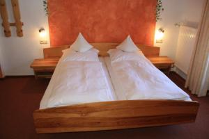 two beds in a room with white sheets and pillows at Alpenpension Auengrund in Ramsau