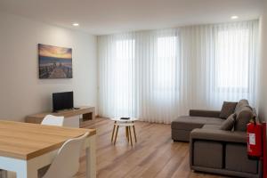 ein Wohnzimmer mit Sofa und Tisch in der Unterkunft Ria Sal apartments in Aveiro