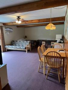 - un salon avec une table, des chaises et un lit dans l'établissement Spring Creek Inn, à Hill City