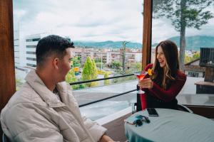a man and a woman sitting at a table with a drink at Hotel Casa del Barranco in Cuenca