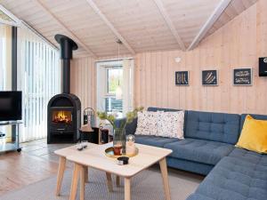 a living room with a blue couch and a fireplace at 6 person holiday home in Hemmet in Falen