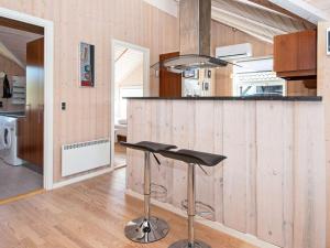 a kitchen with a counter and a bar with a stool at 6 person holiday home in Hemmet in Falen