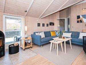 a living room with a blue couch and a table at 6 person holiday home in Hemmet in Falen