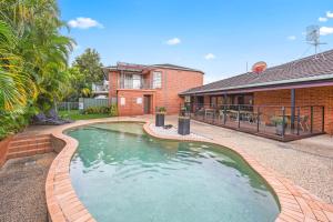 una piscina frente a una casa en Macquarie Barracks Motor Inn, en Port Macquarie