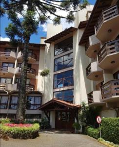 a large building with a tree in front of it at Apart Hotel Pousada do Serrano in Gramado