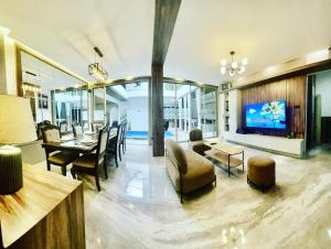 a living room with a tv and a dining room at Radja House Cipaku Indah in Bandung