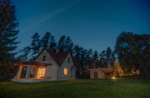 a small white house in a yard at night at Brīvdienu māja Sauleskrasti in Mērsrags