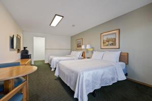 a hotel room with two beds and a table at The Ponderosa in Custer