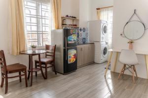 a kitchen with a refrigerator and a table with chairs at Zuchi's Home&Apartment in Da Nang