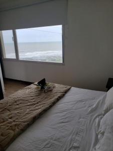1 dormitorio con 1 cama y ventana grande en Bahia dorada departamentos en Quequén