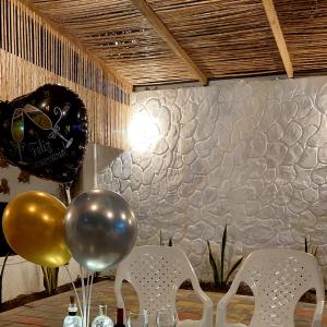 einen Tisch mit Ballons und Flaschen Wein darauf in der Unterkunft Hotel Cabaña Playa DanRay in Coveñas
