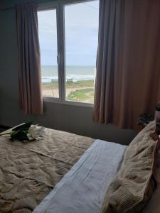 1 dormitorio con 1 cama y vistas al océano en Bahia dorada departamentos en Quequén