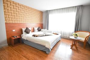 a bedroom with a large bed and a window at CBD Hotel Suratthani in Suratthani