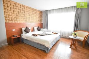 sypialnia z dużym łóżkiem i oknem w obiekcie CBD Hotel Suratthani w mieście Surat Thani