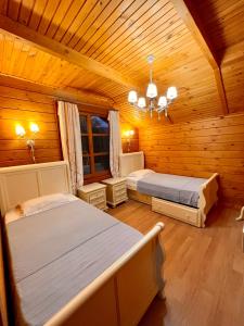 1 dormitorio con 2 camas en una cabaña de madera en Family club Royal-apricot en Tamga