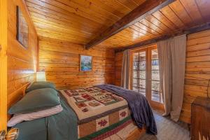 um quarto com uma cama num chalé de madeira em Forest Cabin 1 Hunters Blind em Payson