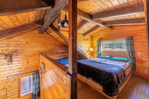 1 dormitorio con 1 cama en una cabaña de madera en Forest Cabin 1 Hunters Blind en Payson