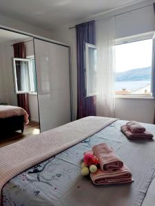 sypialnia z łóżkiem z ręcznikami i kwiatami w obiekcie Apartments Ita 1 - with nice garden w Postirze