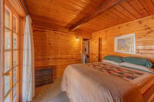 a bedroom with a bed in a wooden cabin at Forest Cabin 2 Birds Nest in Payson