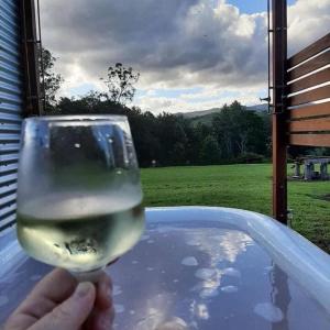 a person holding a glass of wine in a tub at "Mansfield" Cottage Barrington QUALITY HOLIDAY ACCOMMODATION in Barrington