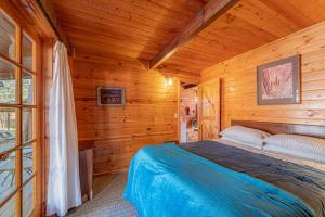 a bedroom with a bed in a wooden cabin at Forest Cabin 3 Bear's Den in Payson