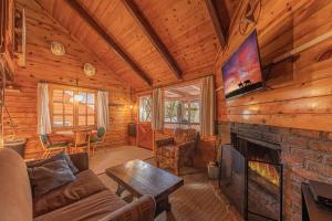 uma sala de estar com lareira num chalé de madeira em Forest Cabin 4 Cowboys Dream em Payson