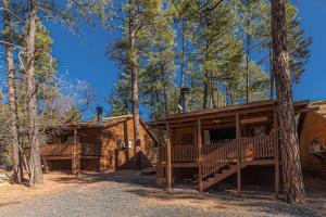 a log cabin in the woods with a porch and stairs at Forest Cabin 4 Cowboys Dream in Payson