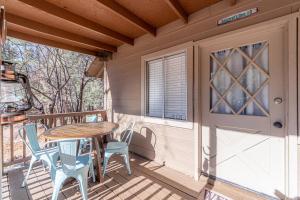 a porch with a wooden table and chairs on it at Hideaway forest cabin 9 Squirrels Den in Payson