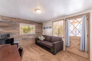 a living room with a couch and a window at Hideaway forest cabin 9 Squirrels Den in Payson