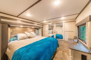 a bedroom with a large bed in a trailer at Luxury Glamper Retreat 14 Forest Site in Payson