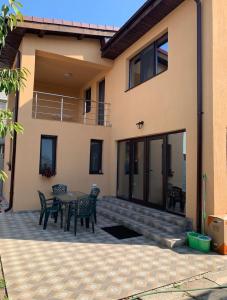 eine Terrasse mit einem Tisch und Stühlen vor einem Haus in der Unterkunft Entire Home in Bukarest