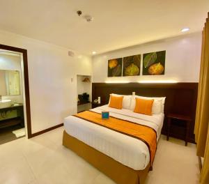 um quarto com uma cama grande e almofadas laranja em Jony's Beach Resort em Boracay