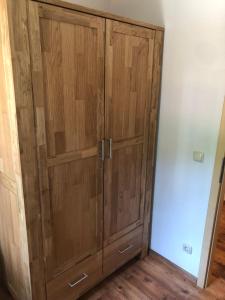 a wooden cabinet with two doors in a room at Sandstein-Ferien, Kamin, Fewo "Wanderfalke", zentral & ruhig, Terrasse, Sächs Schweiz in Königstein an der Elbe