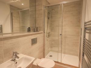 a bathroom with a shower and a toilet and a sink at The Emma Suite Stone Cross Mansion in Ulverston