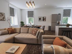 a living room with a couch and a kitchen at The Lucy Suite Stone Cross Mansion in Ulverston